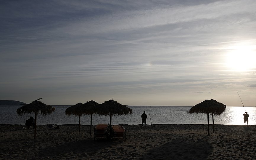 FILE - Three men fish at the sea in Lagonissi, south of Athens on Wednesday, Nov. 7, 2018. (AP Photo/Thanassis Stavrakis)