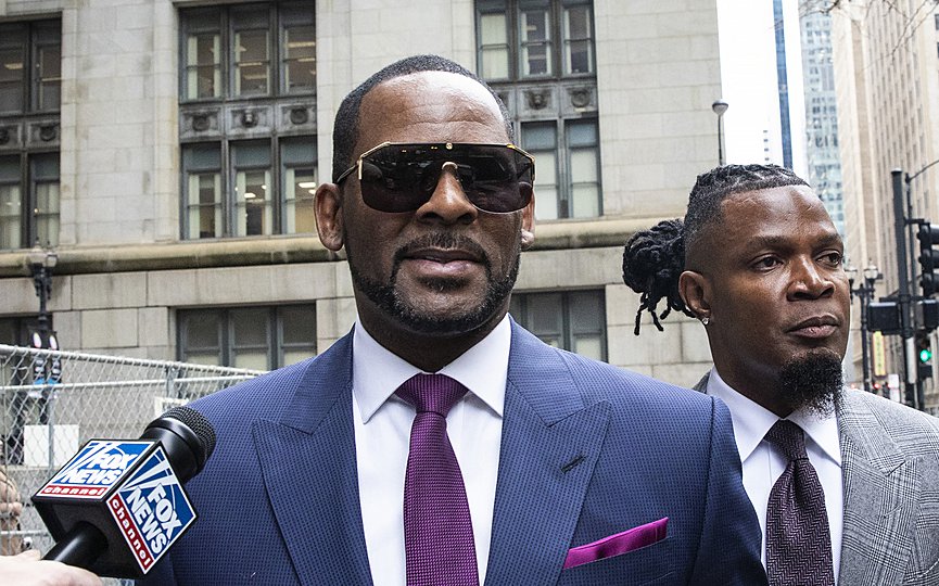 FILE - This March 13, 2019 file photo shows R. Kelly and his publicist Darryll Johnson, right, leaving The Daley Center after an appearance in court for Kelly's child support case in Chicago. Prosecutors in Chicago have charged Kelly with 11 new sex assault charges, some that are more serious than those first filed against him in February. The Chicago Sun-Times reported Thursday, May 30, on its website that the charges include counts that carry a potential sentence of up to 30 years in prison. The charges say the alleged offenses happened in 2010. (Ashlee Rezin/Chicago Sun-Times via AP, File)