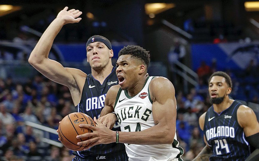 Milwaukee Bucks' Giannis Antetokounmpo goes in for a shot as he gets past Orlando Magic's Aaron Gordon, left, and Khem Birch during the second half of an NBA basketball game Friday, Nov. 1, 2019, in Orlando, Fla. (AP Photo/John Raoux)