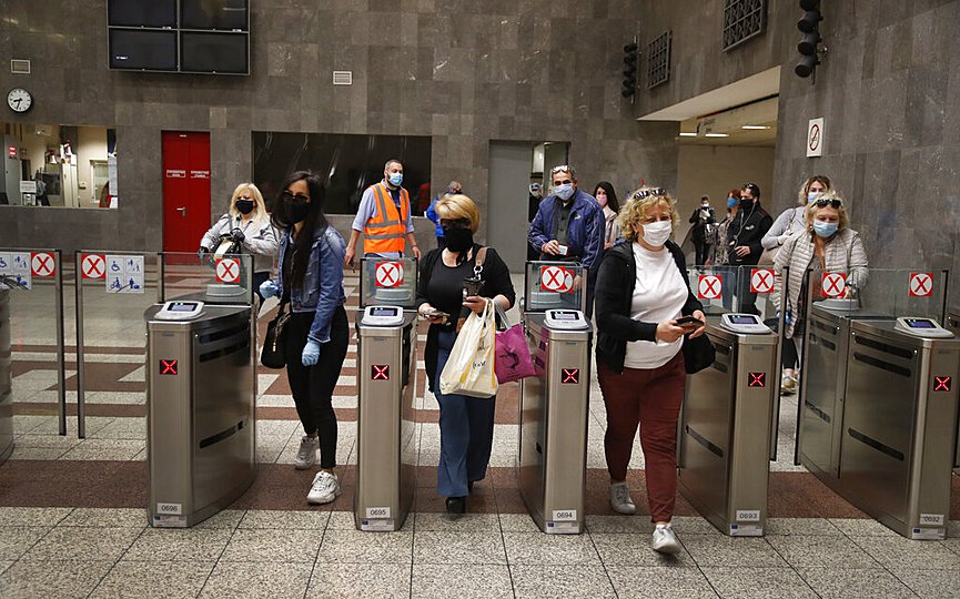 Commuters wearing face masks to prevent the spread of new coronavirus, enter the Syntagma Metro station in central Athens, Monday, May 4, 2020. (AP Photo/Thanassis Stavrakis)