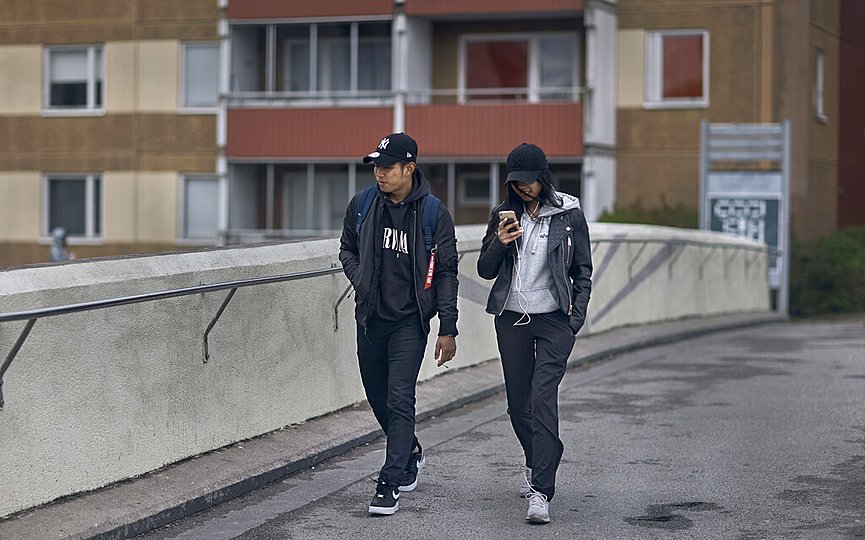 A young couple walks along a bridge in Rinkeby-Kista borough in Stockholm, Sweden, Tuesday, April 28, 2020. (AP Photo/Andres Kudacki)