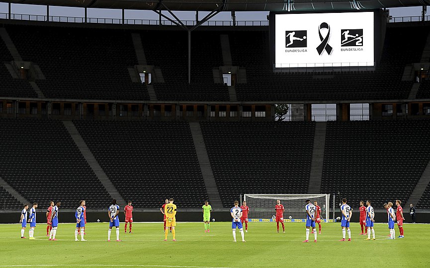 Players observe a minute s silence to commemorate the victims of the coronavirus pandemic prior to the German Bundesliga soccer match between Hertha BSC Berlin and 1. FC Union Berlin in Berlin, Germany, Friday, May 22, 2020. (Stuart Franklin/Pool Photo via AP)