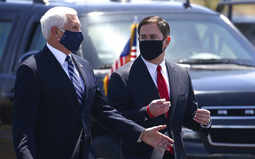 Vice President Mike Pence, left, walks with Arizona Gov. Doug Ducey, right, after their meeting to discuss the surge in coronavirus cases in Arizona Wednesday, July 1, 2020, in Phoenix. (AP Photo/Ross D. Franklin)