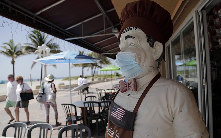 A statue of a chef at Florio s of Little Italy restaurant wears a protective face mask on the Hollywood Beach Broadwalk during the new coronavirus pandemic, Thursday, July 2, 2020, in Hollywood, Fla. (AP Photo/Lynne Sladky)