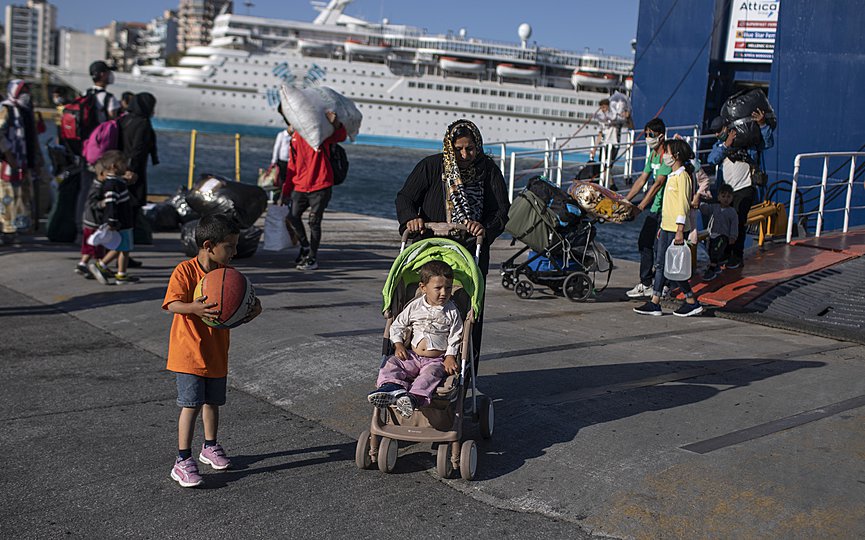 FILE- Refugees and migrants wearing masks arrive at the port of Piraeus , near Athens, on Thursday, June 11, 2020. (AP Photo/Petros Giannakouris)