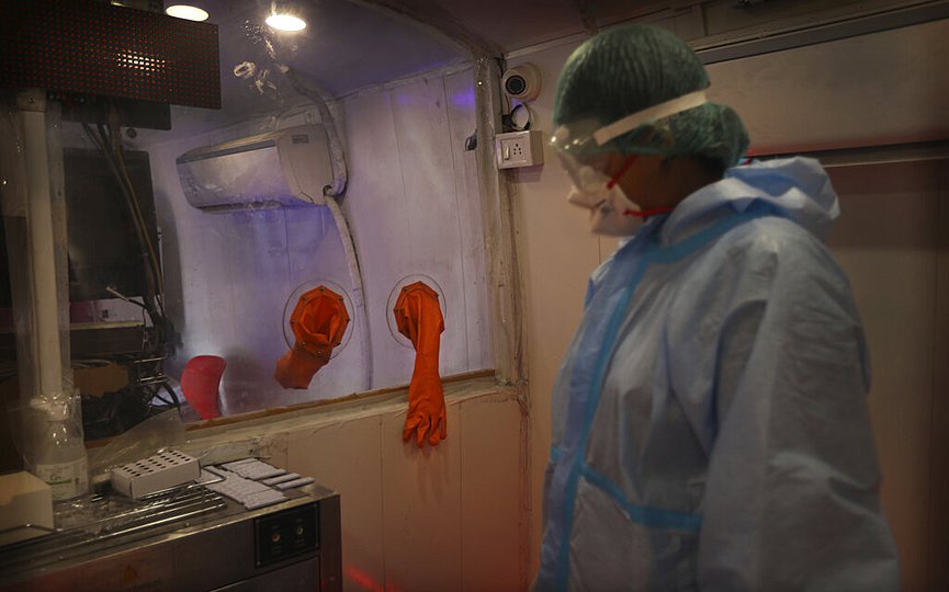 A health worker takes a break in between conducting COVID- 19 testing through rapid antigen methodology inside a mobile lab in New Delhi, India, Monday, Aug. 10, 2020. (AP Photo/Manish Swarup)