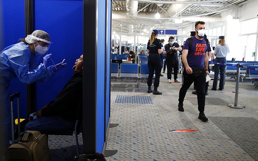 A medical staff conducts a test for the new coronavirus on the passengers who arrived from Doha, Qatar to the Eleftherios Venizelos International Airport in Athens, Monday, June 15, 2020. (AP Photo/Thanassis Stavrakis)