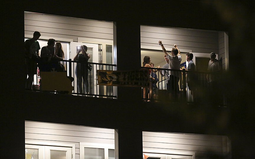 Partiers congregate on the balcony of a downtown apartment on Tuesday, Sept. 1, 2020, in Columbia, Mo., near the University of Missouri campus. (Dan Shular/Missourian via AP)