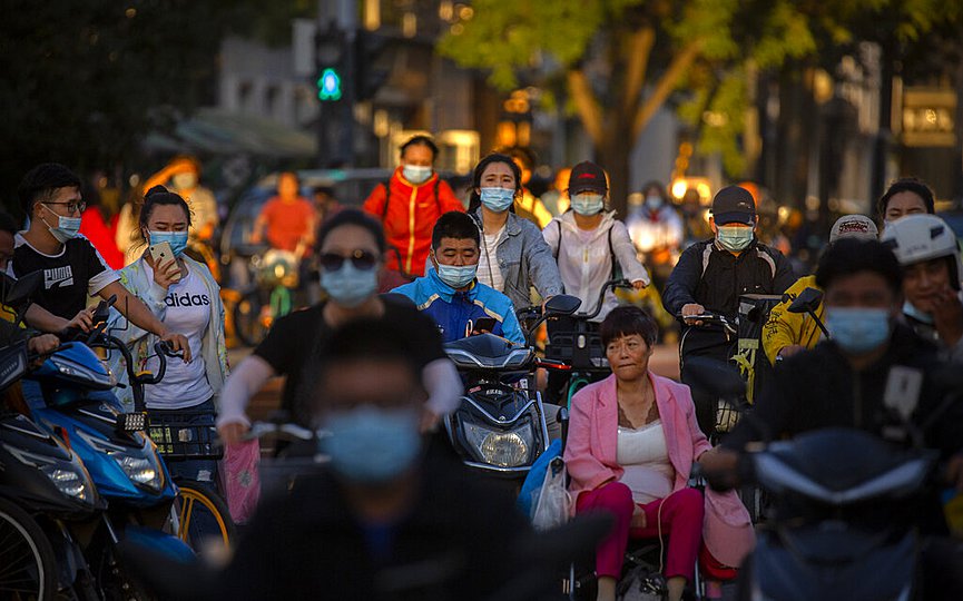People wearing face masks to protect against the coronavirus cross an intersection in Beijing, Wednesday, Sept. 16, 2020. (AP Photo/Mark Schiefelbein)