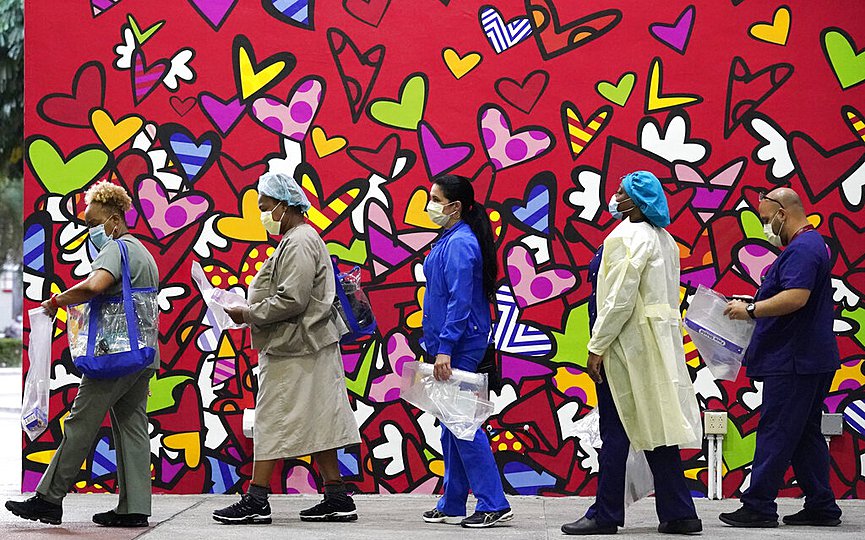 FILE - In this Sept. 22, 2020, file photo, healthcare workers line up for free personal protective equipment in front of a mural by artist Romero Britto at Jackson Memorial Hospital in Miami. (AP Photo/Wilfredo Lee)