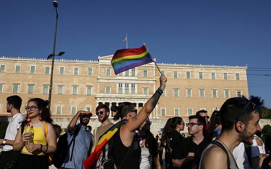 FILE- A demonstrator waves a rainbow flag during the annual Gay Pride rally, in front of parliament, in Athens (AP Photo/Yorgos Karahalis)