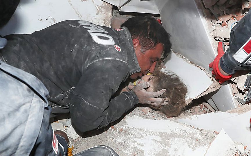 In this photo provided by the government s Search and Rescue agency AFAD, rescue workers, who were trying to reach survivors in the rubble of a collapsed building, surround Ayda Gezgin in the Turkish coastal city of Izmir, Turkey, Tuesday, Nov. 3, 2020, as they pull the young girl out alive from the rubble of a collapsed apartment building four days after a strong earthquake hit Turkey and Greece. (AFAD via AP)