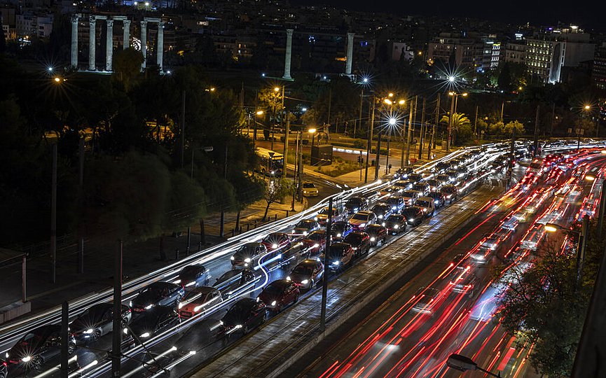 Traffic jams a main road in central Athens, as at the background stands the ancient temple of Zeus, on Friday, Nov. 6, 2020, one day before the new national lockdown starts. (AP Photo/Petros Giannakouris)