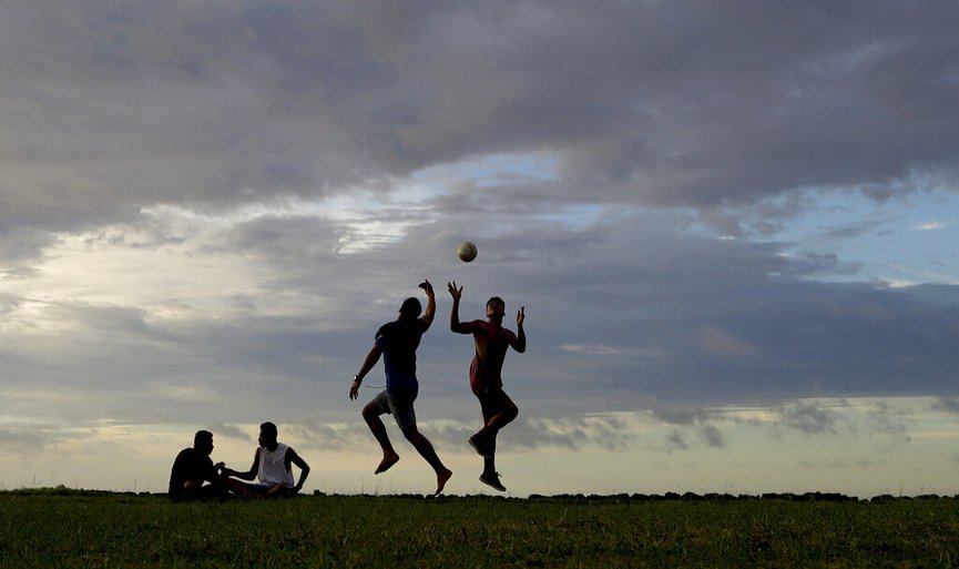 FILE - In this April 10, 2019, file photo, young men play a game of rugby at sunset in Nuku alofa, Tonga. (AP Photo/Mark Baker, File)