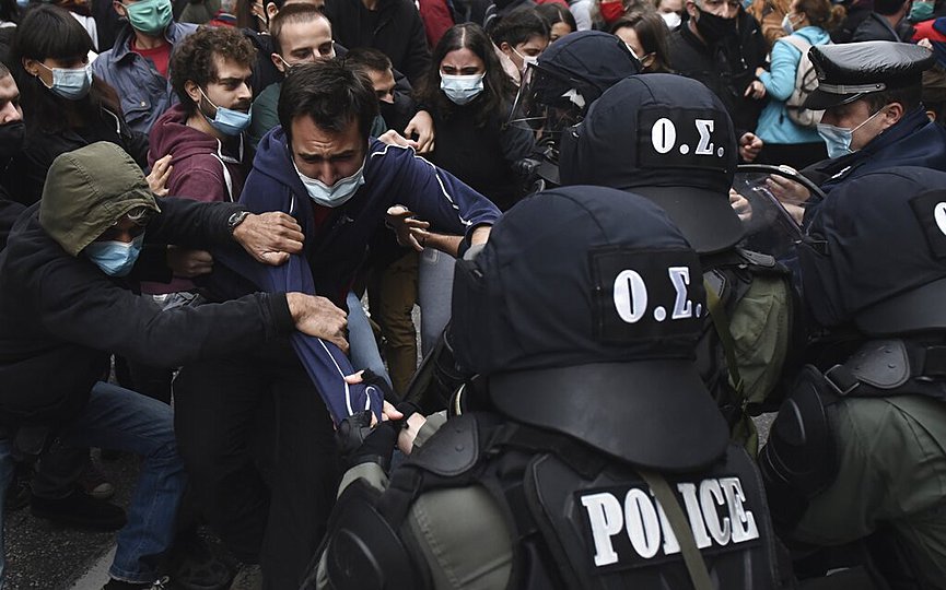 Protesters resist as police try to detain a man during a banned rally in the northern city of Thessaloniki, Greece, Tuesday, Nov. 17, 2020. (AP Photo/Giannis Papanikos)