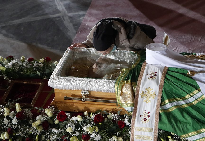 A woman kisses the coffin of Patriarch Irinej as he lies in repose at the St. Sava Temple in Belgrade, Serbia, Saturday, Nov. 21, 2020. (AP Photo/Darko Vojinovic)