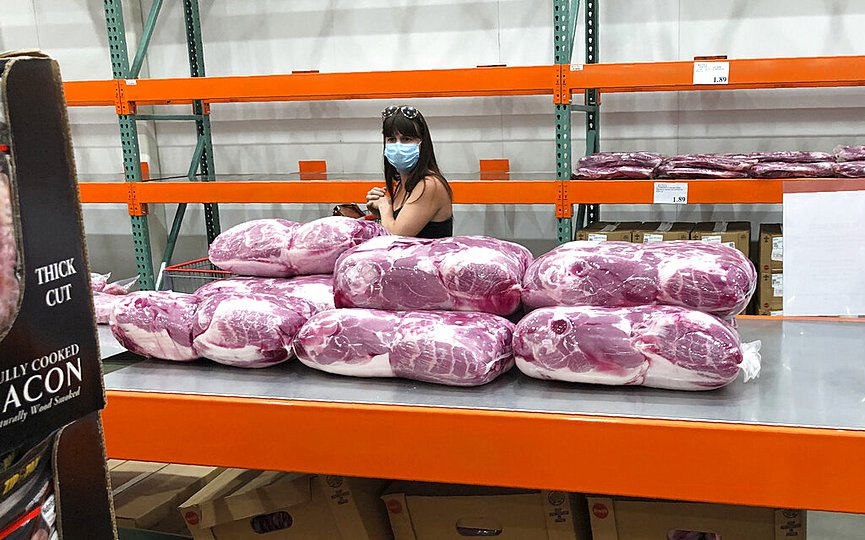 A shopper in a face mask looks over cuts of beef piled up in a cold room for purchase at a Costco warehouse store Tuesday, May 5, 2020, in west Denver. (AP Photo/David Zalubowski)