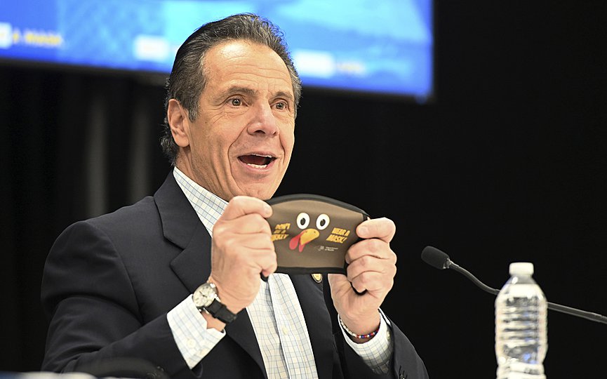 In this provided by the State of New York, New York Gov. Andrew Cuomo holds up a new Thanksgiving-themed face mask during his daily coronavirus briefing at the Wyandanch-Wheatley Heights Ambulance Corp. Headquarters in Wyandanch, N.Y. (Kevin P. Coughlin/State of New York via AP)
