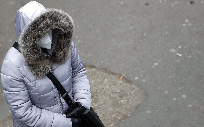 A woman wearing a mask against the spread of the coronavirus waits at a bus station in Belgrade, Serbia, Friday, Nov. 27, 2020. (AP Photo/Darko Vojinovic)