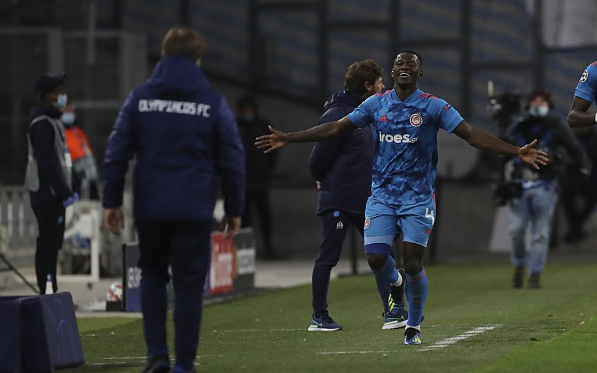 Olympiacos  Mady Camara , right, runs to Olympiacos  manager Pedro Martins ,after scoring the opening goal during the Champions League group C soccer match between Olympique Marseille and Olympiacos at the Velodrome stadium in Marseille, southern France, Tuesday, Dec. 1, 2020. (AP Photo/Daniel Cole)