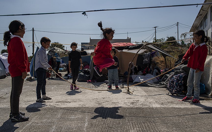 Children play as migrants gather on the roadside near Mytilene town, on the northeastern island of Lesbos, Greece, Monday, Sept. 14, 2020.  (AP Photo/Petros Giannakouris)