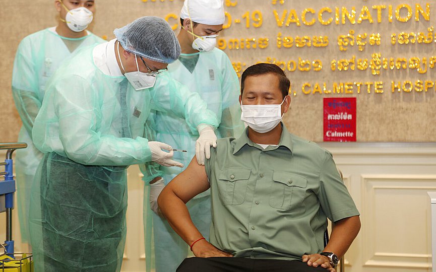 Cambodia s Lt. Gen. Hun Manet, right, a son of Prime Minister Hun Sen, receives a shot of the COVID-19 vaccine at Calmette hospital in Phnom Penh, Cambodia, Wednesday, Feb. 10, 2021. (AP Photo/Heng Sinith)