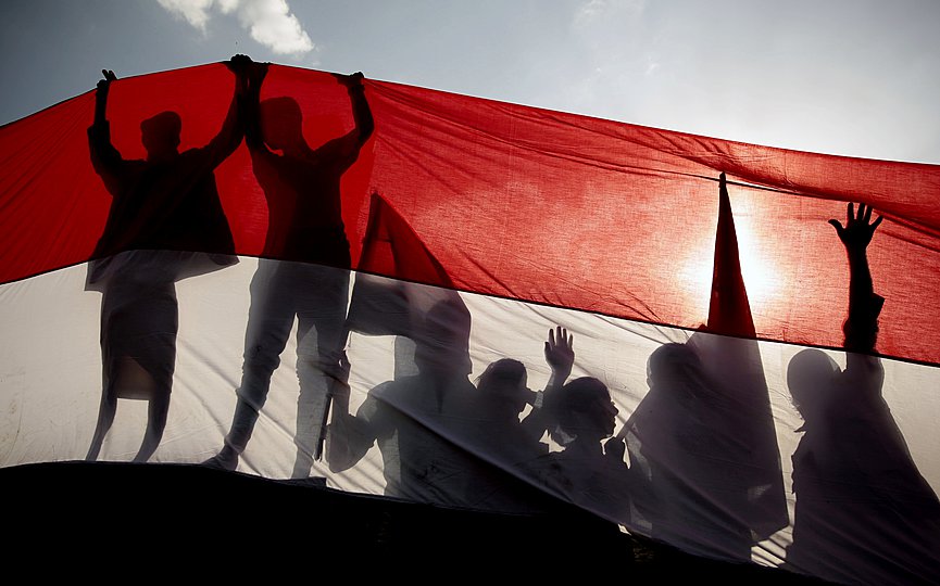 FILE - In this Sept. 26, 2016 file photo, men are silhouetted against a large representation of the Yemeni flag as they attend a ceremony to mark the anniversary of North Yemen s 1962 revolution in Sanaa, Yemen. (AP Photo/Hani Mohammed, File)