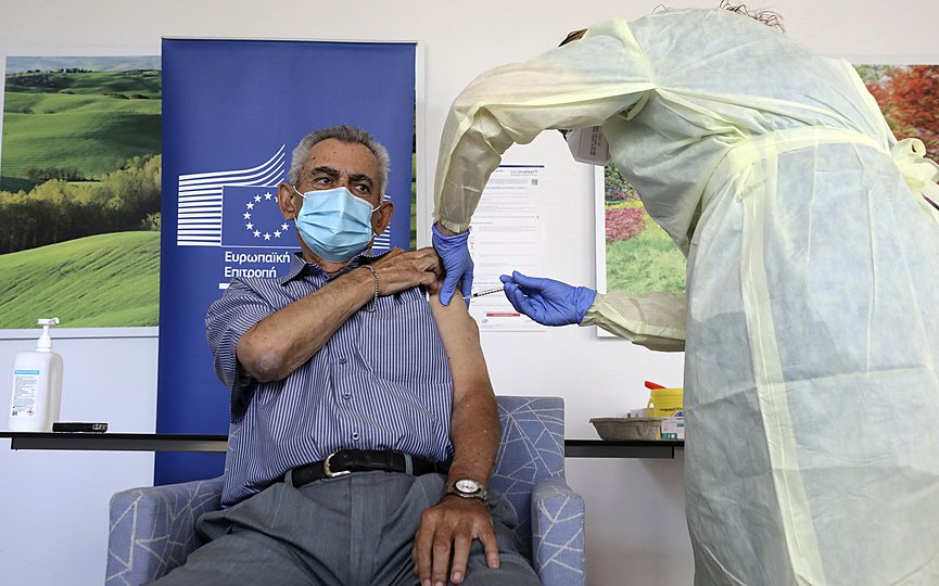 Andreas Raounas, 84, the first patient in Island receives from a nurse the vaccine of Pfizer BioNtech against the COVID-19, at a care home in Nicosia, Cyprus, on Sunday, Dec. 27, 2020. (Katia Christodoulou/Pool Photo via AP)