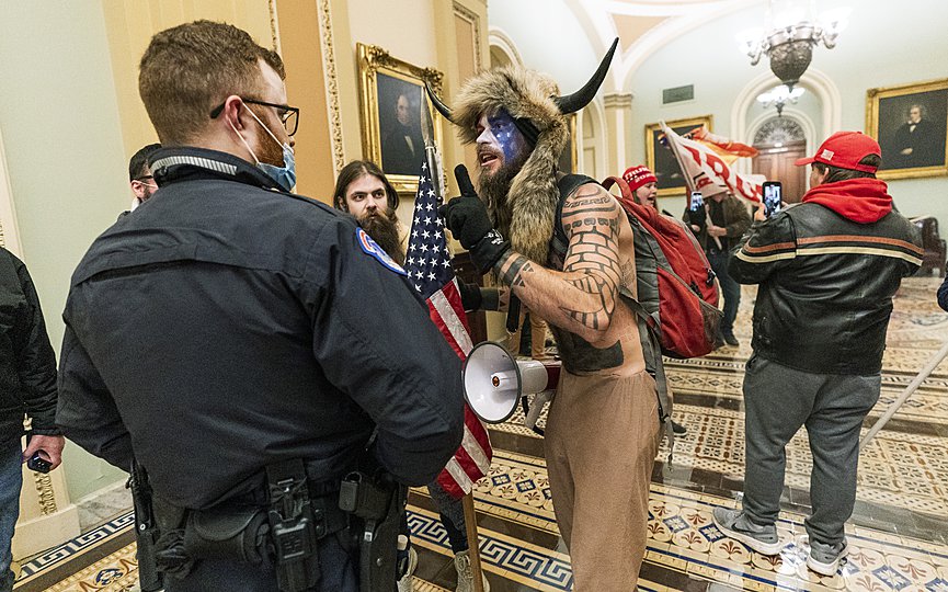 FILE - In this Jan. 6, 2021, file photo supporters of President Donald Trump are confronted by U.S. Capitol Police officers outside the Senate Chamber inside the Capitol in Washington. An Arizona man seen in photos and video of the mob wearing a fur hat with horns was also charged Saturday in Wednesday s chaos. Jacob Anthony Chansley, who also goes by the name Jake Angeli, was taken into custody Saturday, Jan. 9. (AP Photo/Manuel Balce Ceneta, File)