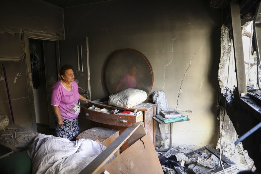 Julianna Sror looks at the damage to her apartment after being hit by a rocket fired from the Gaza Strip over night, in Petah Tikva, central Israel, Thursday, May 13, 2021. (AP Photo/Oded Balilty)