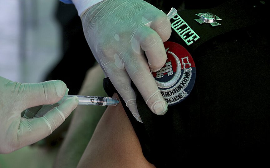 A police officer receives his first of the Sinopharm coronavirus vaccine, at a vaccination center in the police headquarters, in Peshawar, Pakistan, Monday, May 24, 2021. (AP Photo/Muhammad Sajjaad)