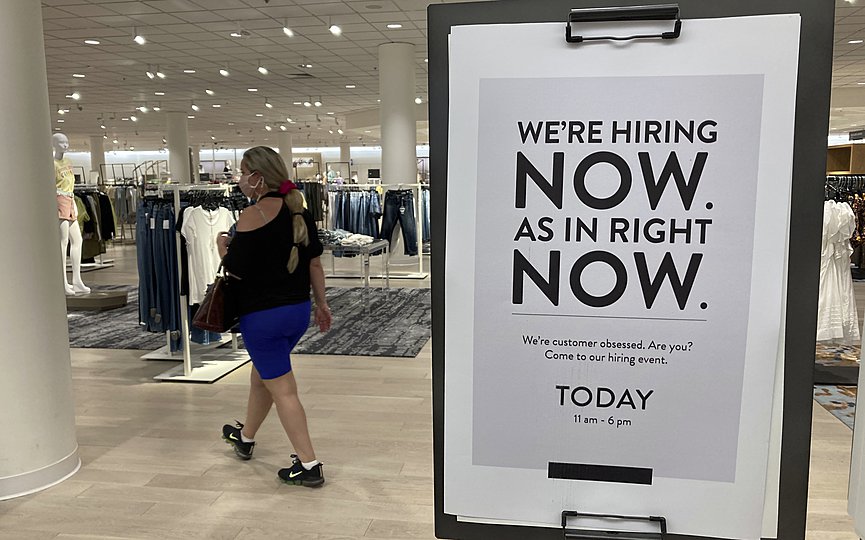 A customer walks behind a sign at a Nordstrom store seeking employees, Friday, May 21, 2021, in Coral Gables, Fla. (AP Photo/Marta Lavandier)