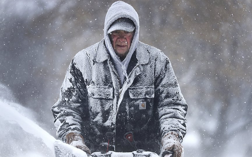 Gary Verstegen clears a sidewalk as a winter storm moves through Wisconsin on Monday, Jan. 28, 2019, in Little Chute, Wis. (William Glasheen/The Post-Crescent via AP)