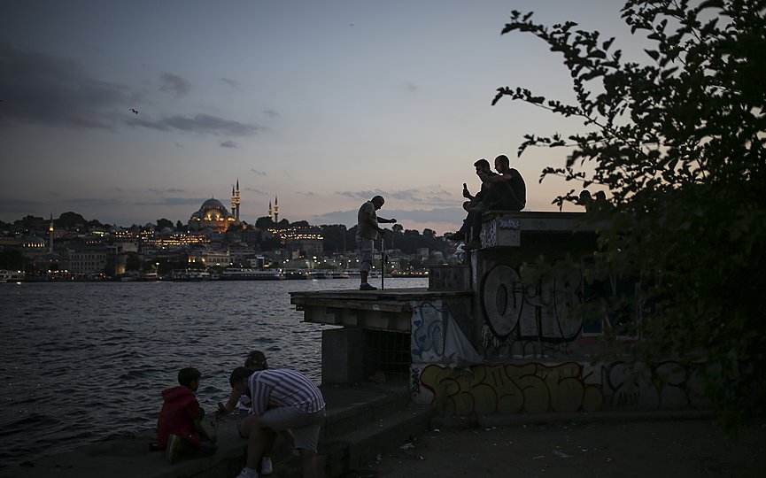 People spend time by the Golden Horn leading to the Bosporus Strait, separating Europe and Asia in Istanbul, Sunday, July 4, 2021. (AP Photo/Emrah Gurel)