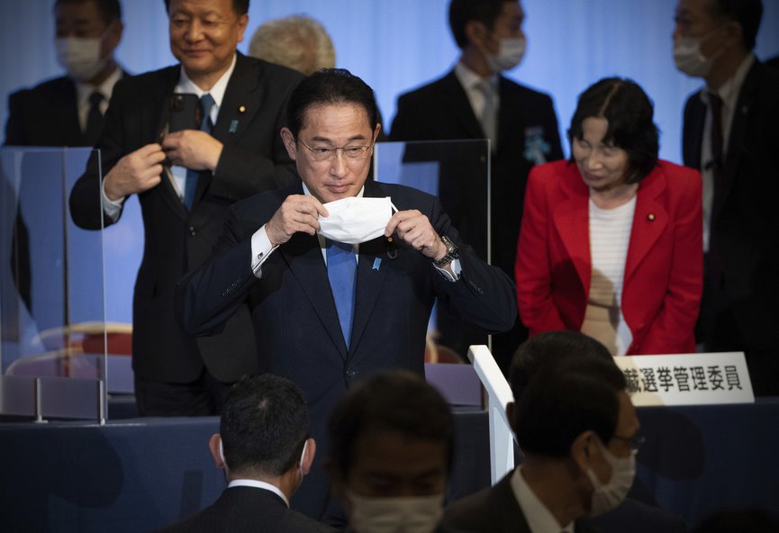 Japan s former Foreign Minister Fumio Kishida, center, puts on his face mask as he leaves the stage after winning the Liberal Democrat Party leadership election in Tokyo Wednesday, Sept. 29, 2021. (Carl Court/Pool Photo via AP)